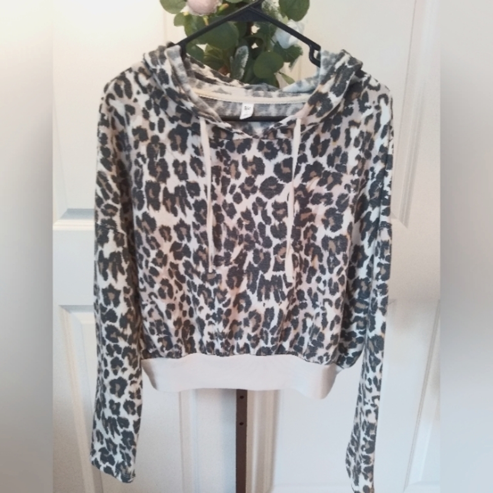 Pullover hoodie with animal print design and is almost cropped length.